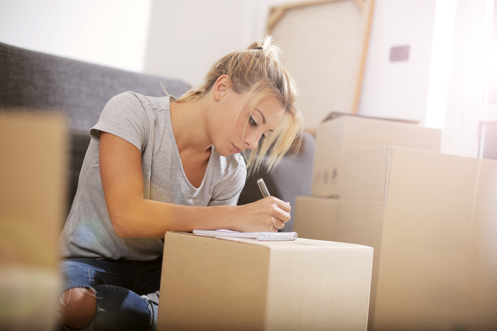 Woman organizes boxes to prepare for moving