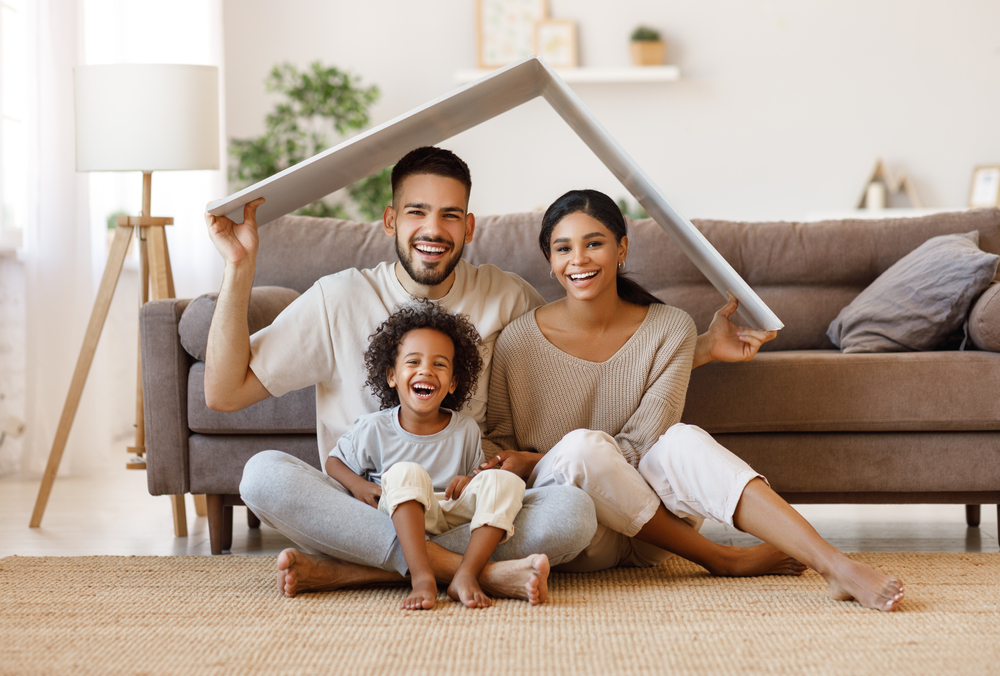 Family smiles together while holding a moving box