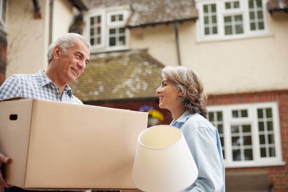 Older couple packs boxes together, downsizing for retirement